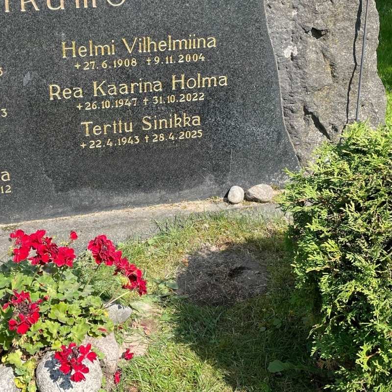 Nimen lisäys hautakiveen.